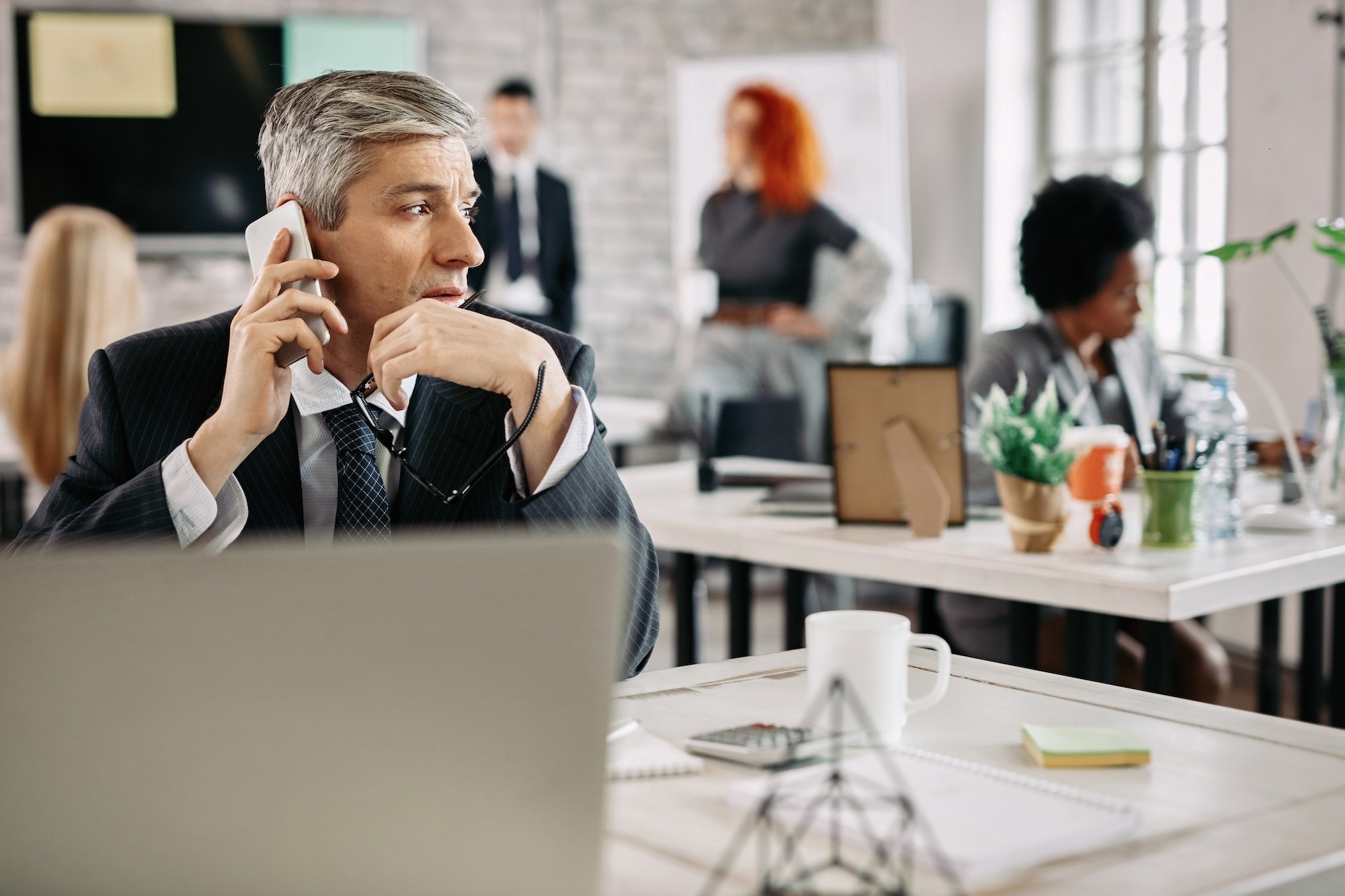 pensive-businessman-talking-on-cell-phone-in-the-o-2026-01-07-05-58-08-utc